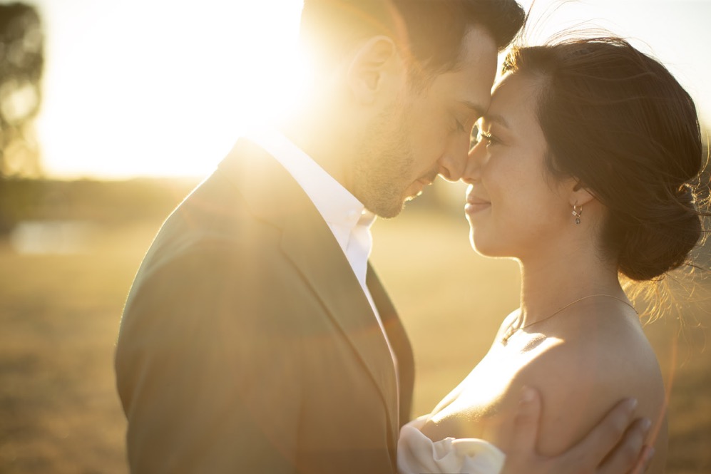 A newlywed couple sharing a warm sunset moment at Zonzo Estate