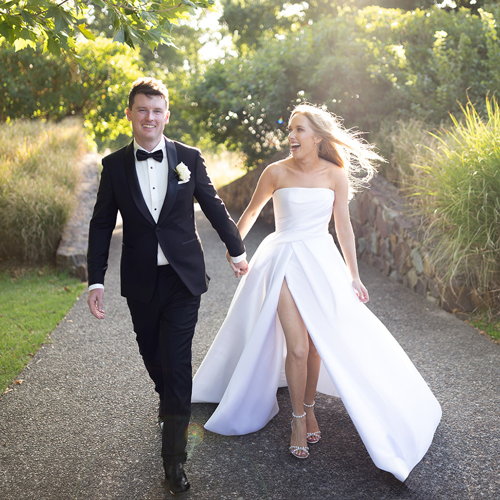 Newlyweds walking through sunlit gardens at Yering Station