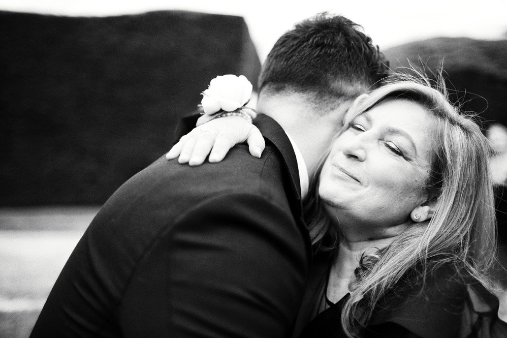 A woman and a man sharing a heartfelt hug, with the woman smiling warmly.