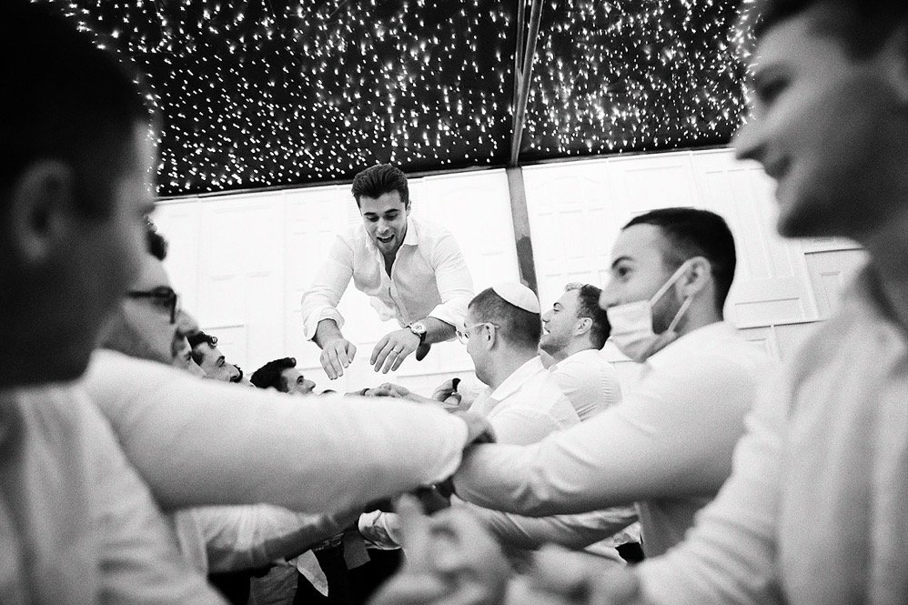 Group of men participating in a traditional dance under a starry ceiling